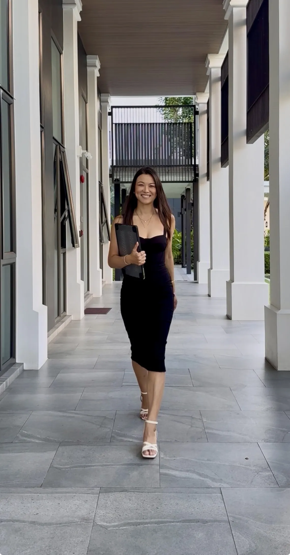 Alice Muse walking through a light-filled colonnade